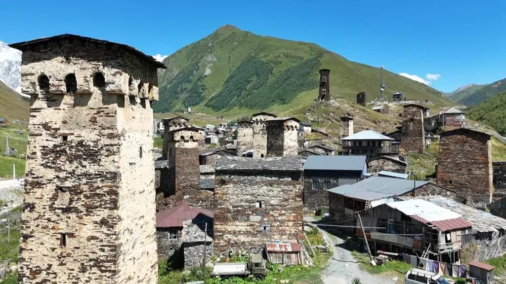Tours défensives médiévales d’Ushguli, Svanétie (Géorgie), au pied des montagnes verdoyantes sous ciel bleu.