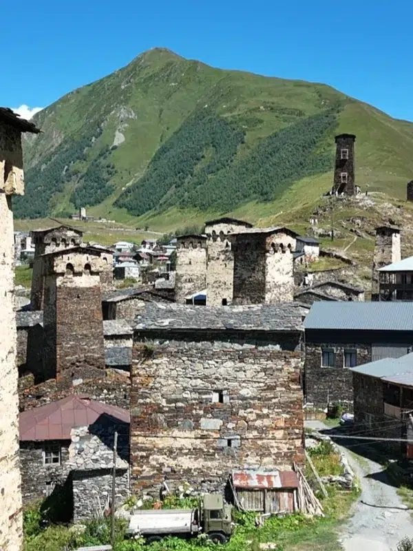 Tours défensives médiévales d’Ushguli, Svanétie (Géorgie), au pied des montagnes verdoyantes sous ciel bleu.