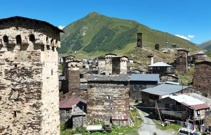Tours défensives médiévales d’Ushguli, Svanétie (Géorgie), au pied des montagnes verdoyantes sous ciel bleu.
