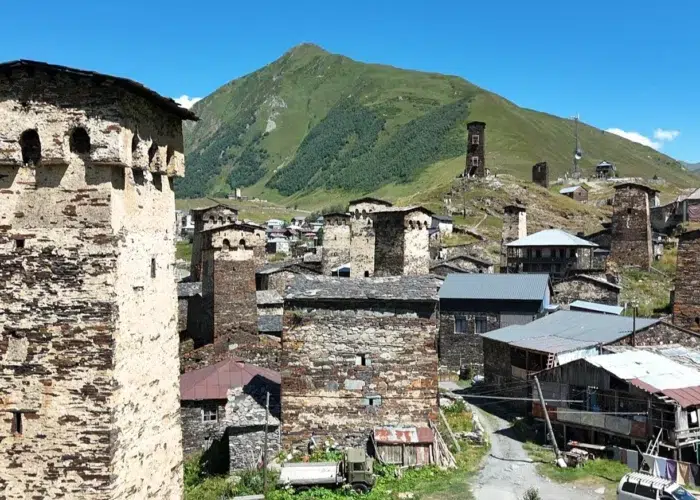 Tours défensives médiévales d’Ushguli, Svanétie (Géorgie), au pied des montagnes verdoyantes sous ciel bleu.