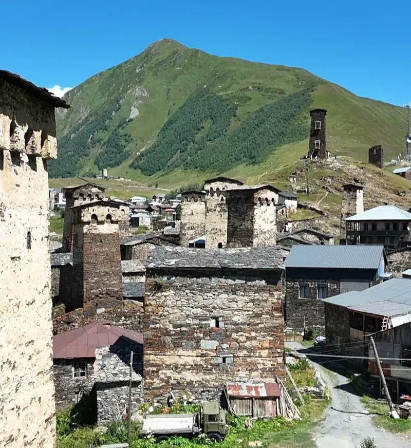 Tours défensives médiévales d’Ushguli, Svanétie (Géorgie), au pied des montagnes verdoyantes sous ciel bleu.